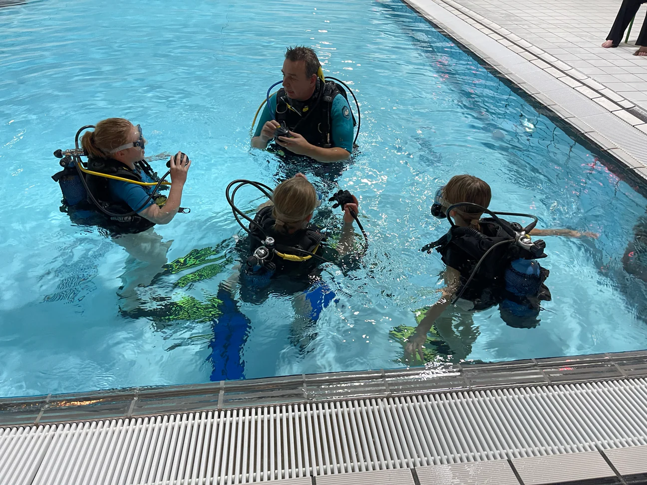 Duikinstructeur begeleidt studenten in het zwembad